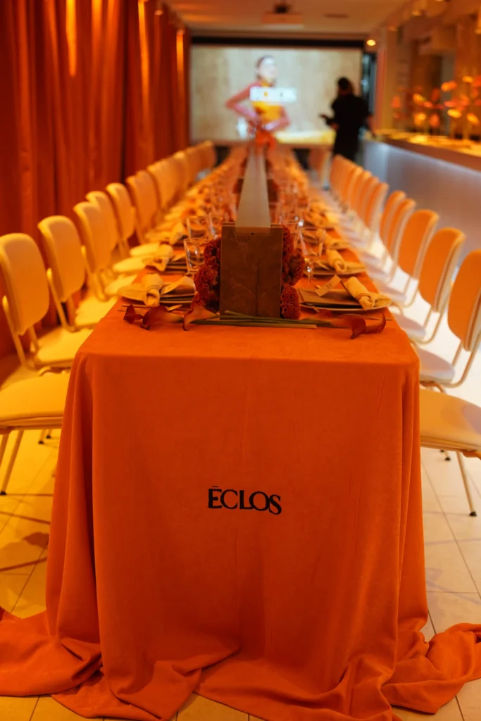 Mesa imperial con mantel naranja y el logo de Eclos bordado