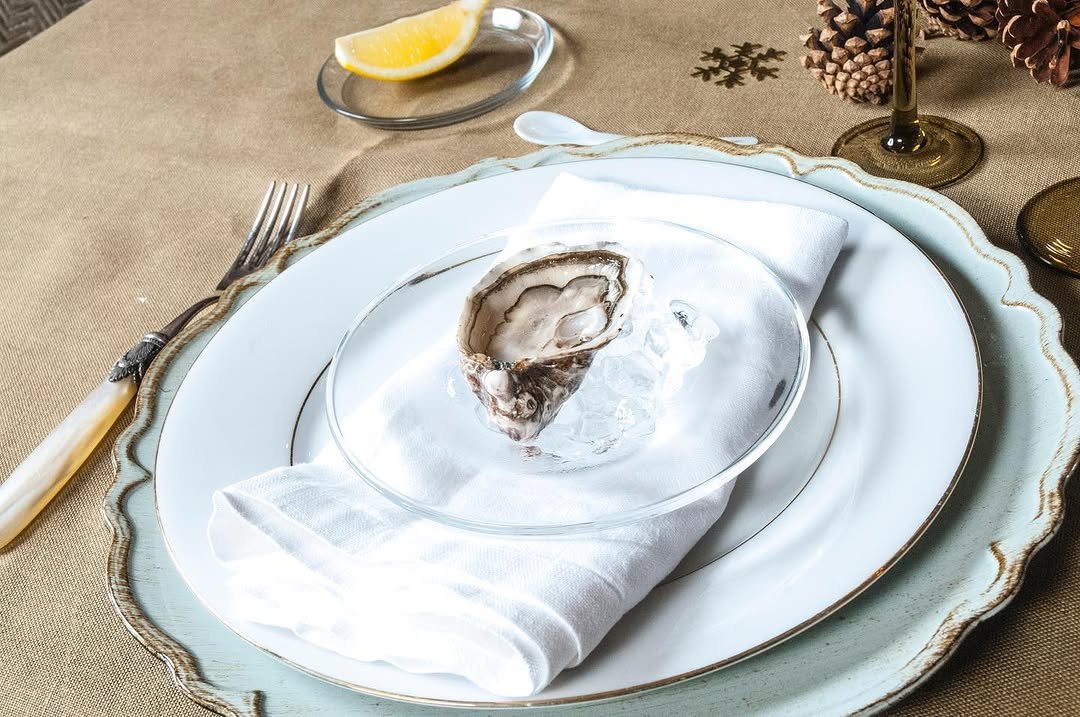 Ostra servida en plato con servilleta de lino, fotografía de MUYNEGRE
